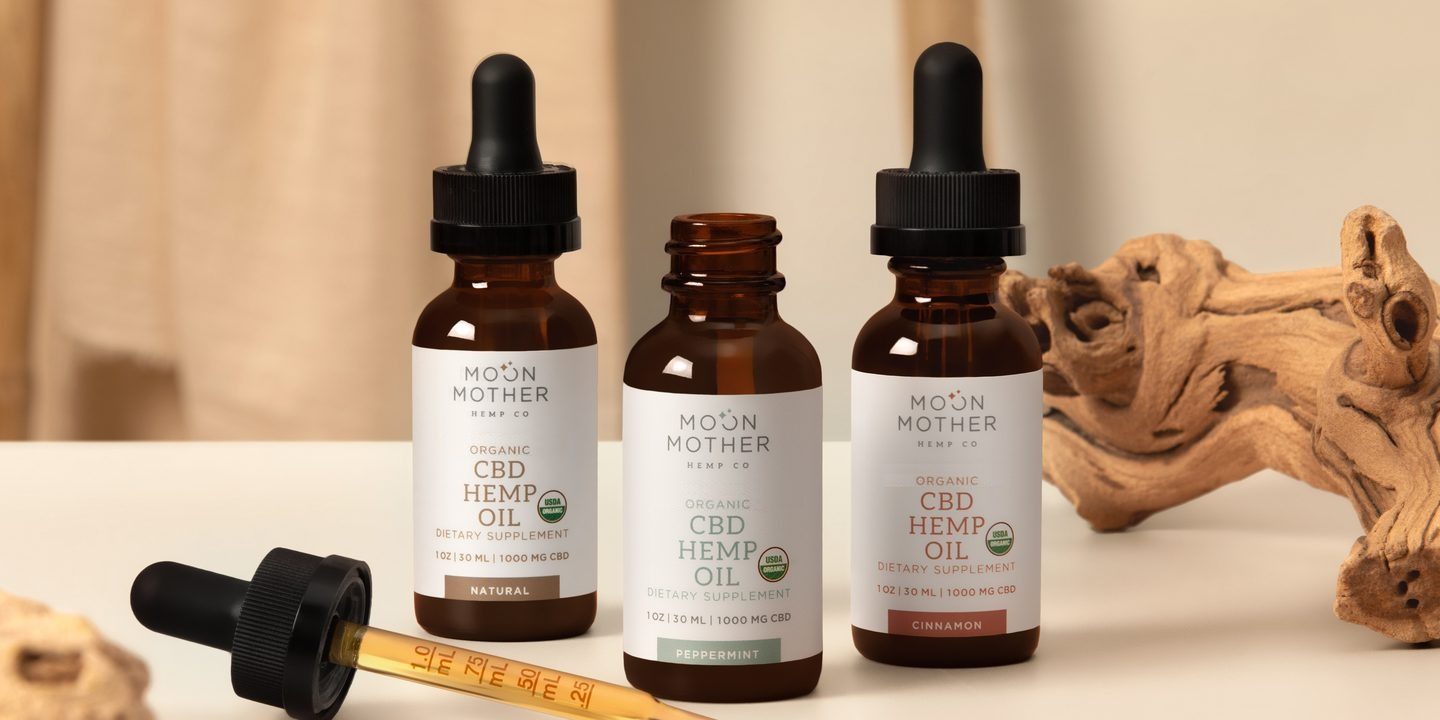 Three hemp oil tinctures with a dropper on a sunlit table