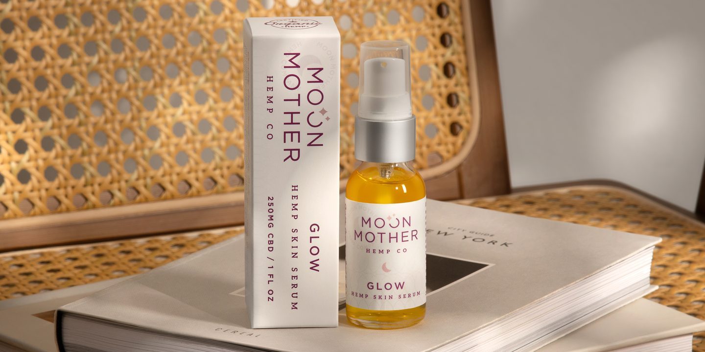 Glow Skin Serum on a stack of books by a cane chair