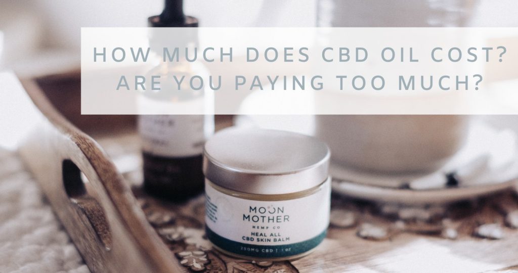 A CBD Skin Balm jar and tincture on a wooden tray, with the words How Much Does CBD Oil Cost? Are You Paying Too Much?