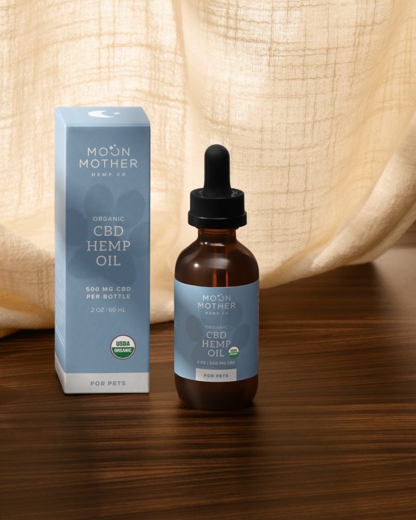 CBD Hemp Oil for pets beside its box, draped linen behind